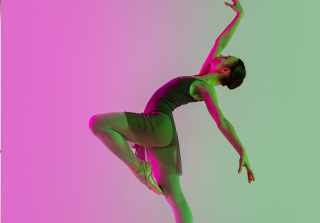 ballet dancer performing under pink and green lighting