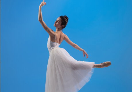 ballerina performing pose on blue background